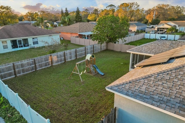 view of yard with a residential view, a fenced backyard, and a playground