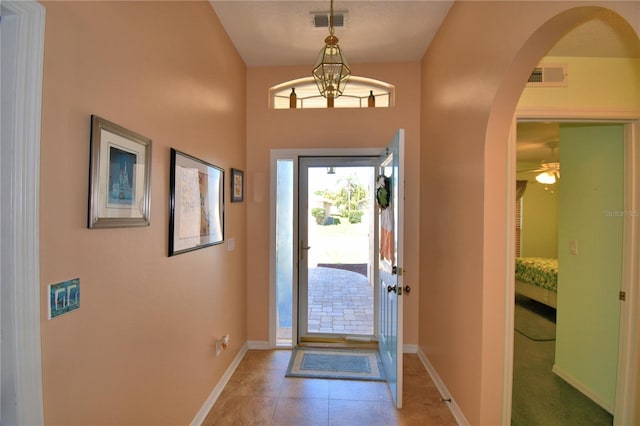 entrance foyer featuring visible vents, baseboards, and arched walkways