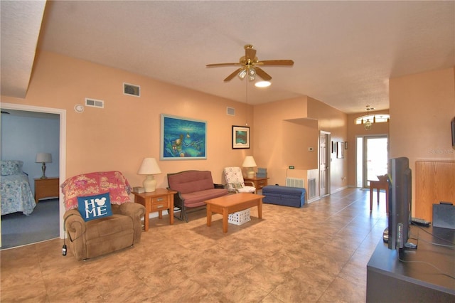 living area with ceiling fan with notable chandelier and visible vents