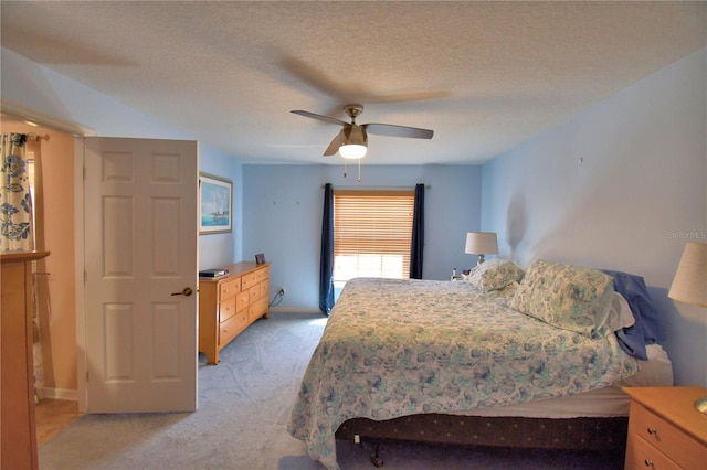 bedroom with baseboards, light colored carpet, a textured ceiling, and ceiling fan