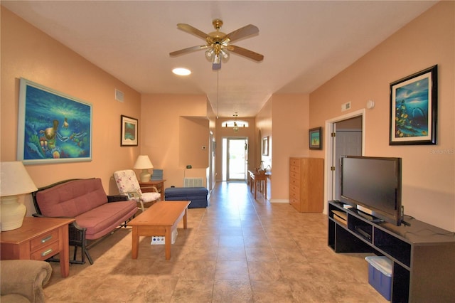 living room with ceiling fan with notable chandelier, visible vents, and baseboards