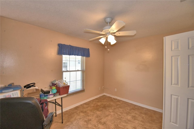 office area with a ceiling fan and baseboards