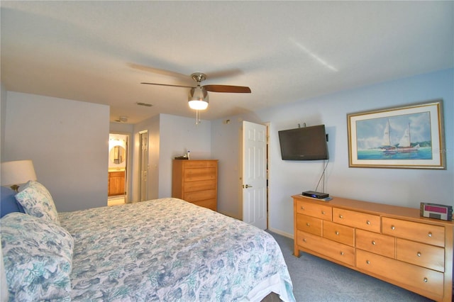 carpeted bedroom featuring visible vents, ensuite bathroom, and ceiling fan