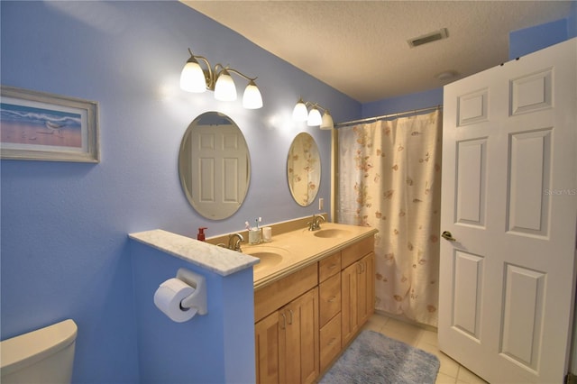 full bathroom with a sink, visible vents, toilet, and tile patterned flooring