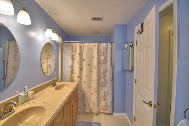 bathroom with tile patterned flooring, a textured ceiling, visible vents, and a sink