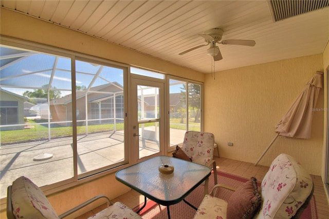 sunroom / solarium featuring visible vents, a residential view, ceiling fan, and wooden ceiling