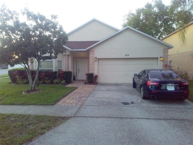 ranch-style home with driveway, an attached garage, and stucco siding