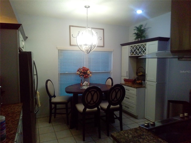 dining space featuring light tile patterned floors and a chandelier