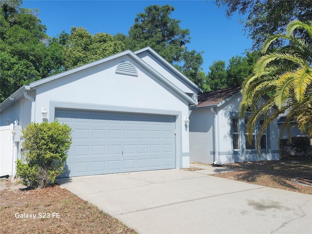 1346 Rolling River Rd, Deland, FL 32720 - ranch-style house with stucco siding, concrete driveway, and a garage