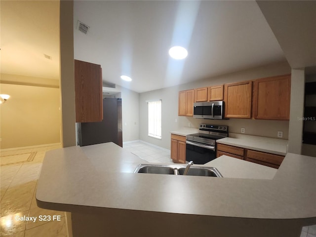 1346 Rolling River Rd, Deland, FL 32720 - kitchen featuring appliances with stainless steel finishes, a sink, lofted ceiling, light tile patterned floors, and light countertops