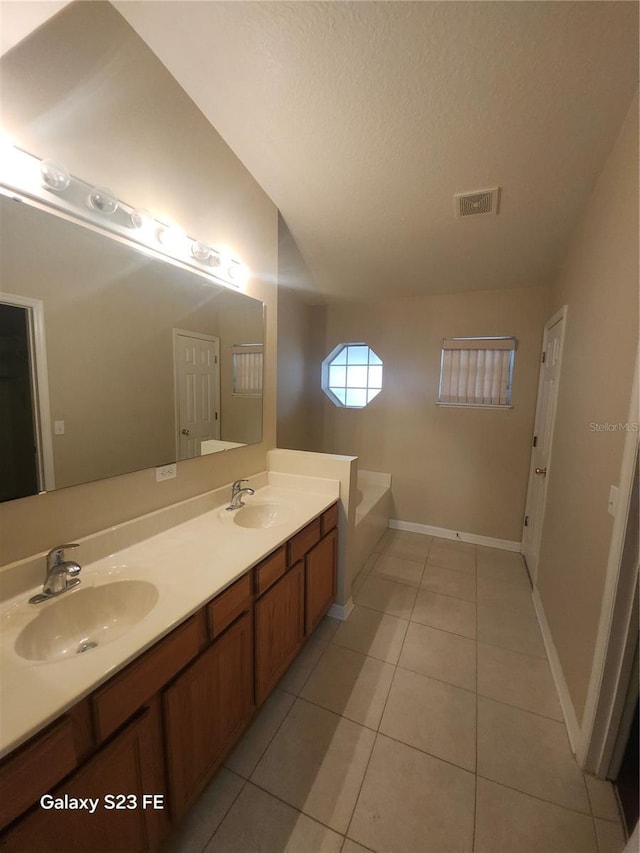 1346 Rolling River Rd, Deland, FL 32720 - full bath featuring double vanity, tile patterned floors, a textured ceiling, a bath, and baseboards