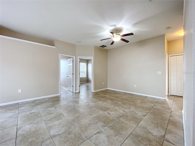 empty room featuring light tile patterned floors, baseboards, a ceiling fan, and a textured ceiling