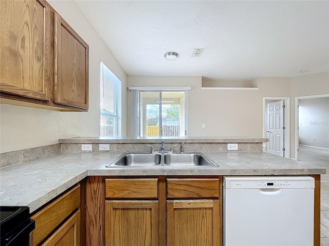 kitchen featuring visible vents, a sink, black range with electric cooktop, dishwasher, and a peninsula