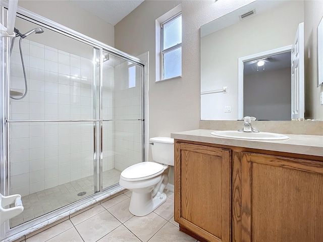 bathroom featuring a stall shower, visible vents, toilet, tile patterned floors, and vanity