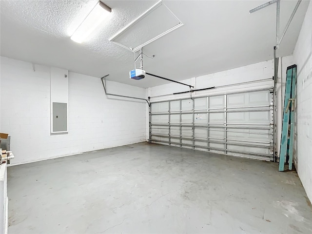 garage featuring a garage door opener, concrete block wall, and electric panel