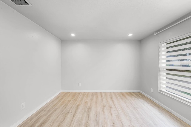 unfurnished room featuring recessed lighting, visible vents, baseboards, and wood finished floors