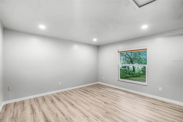 spare room with light wood finished floors, recessed lighting, and baseboards