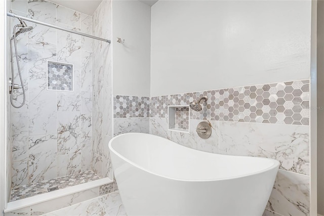 full bath with a freestanding bath, tile walls, and tiled shower