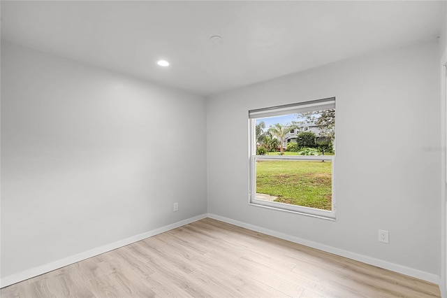 empty room with recessed lighting, light wood finished floors, and baseboards