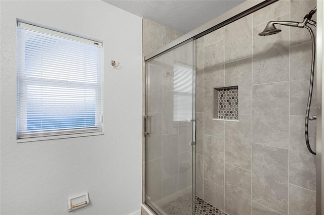 full bath with a stall shower and a textured ceiling