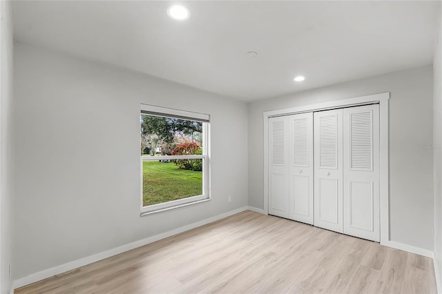 unfurnished bedroom with light wood-style floors, recessed lighting, a closet, and baseboards