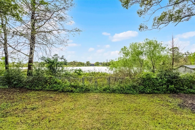 view of yard with a water view and fence