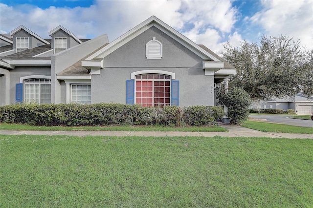 view of front of property with a front yard and stucco siding