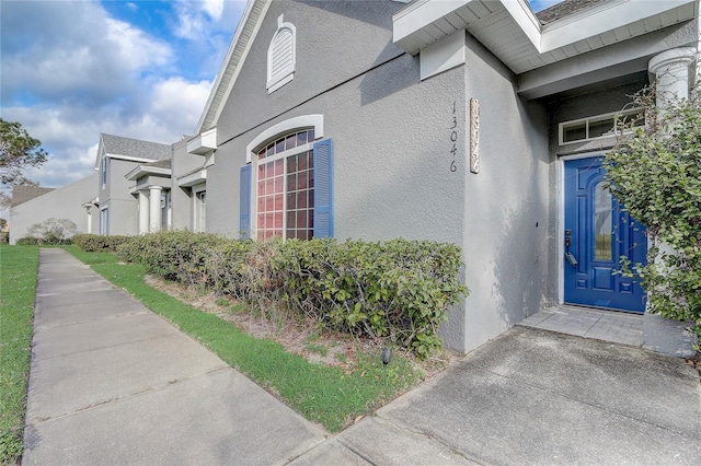 doorway to property featuring stucco siding