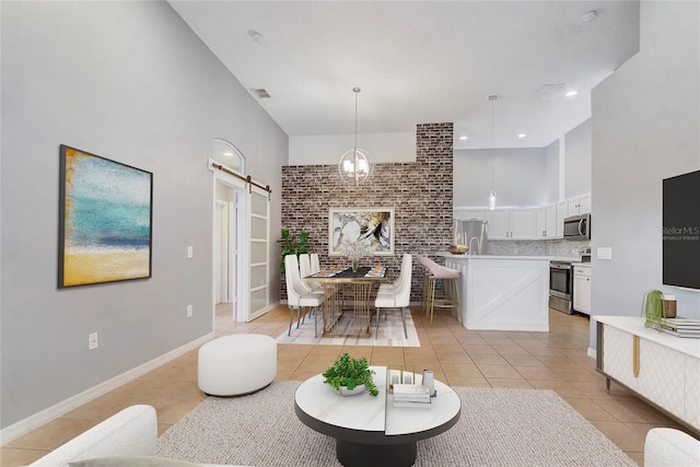 living area with light tile patterned floors, visible vents, a high ceiling, a barn door, and baseboards