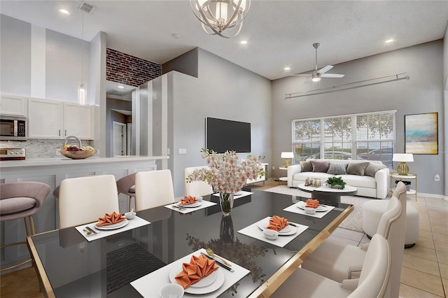 dining area featuring ceiling fan, light tile patterned flooring, recessed lighting, a towering ceiling, and visible vents