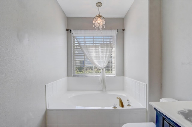 full bath featuring toilet, a garden tub, vanity, and an inviting chandelier