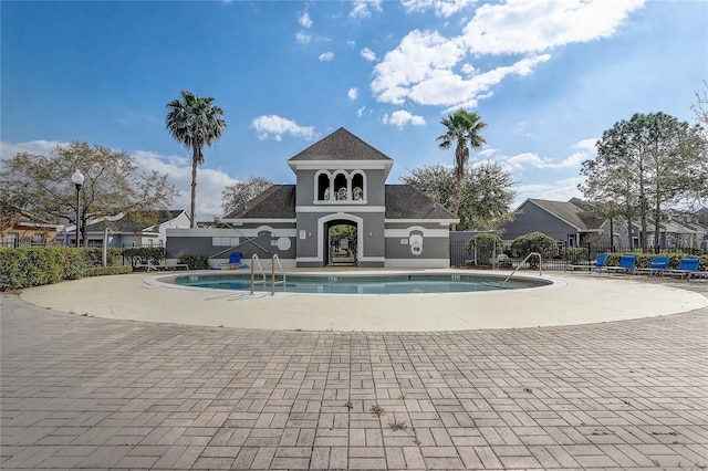 community pool with fence and a patio