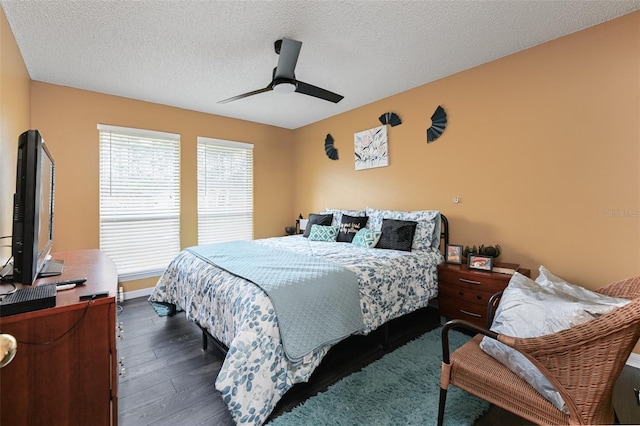 bedroom with a textured ceiling, dark wood-type flooring, a ceiling fan, and baseboards