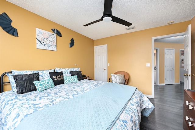 bedroom featuring a textured ceiling, ceiling fan, visible vents, baseboards, and dark wood finished floors