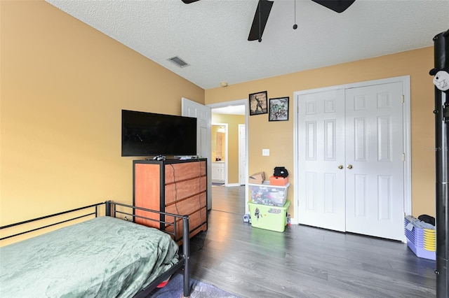 bedroom with visible vents, a ceiling fan, wood finished floors, a textured ceiling, and a closet