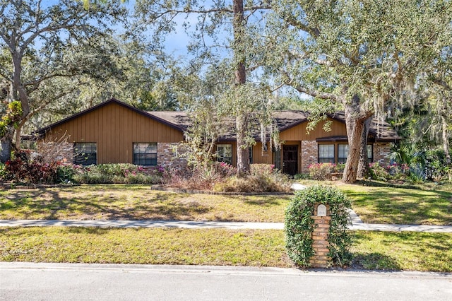 ranch-style home featuring a front yard and brick siding