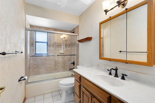 bathroom with bath / shower combo with glass door, visible vents, toilet, vanity, and tile patterned flooring