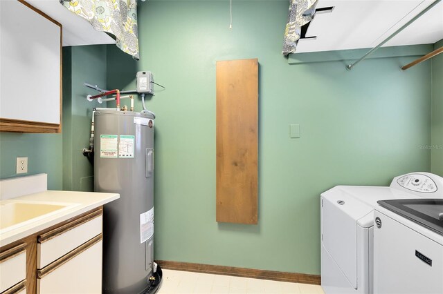 laundry room featuring washing machine and dryer, electric water heater, cabinet space, and baseboards