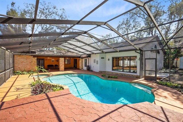 outdoor pool featuring glass enclosure and a patio area