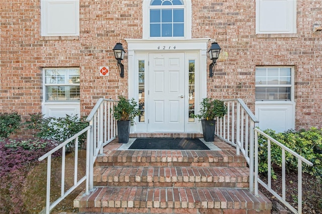 entrance to property featuring brick siding