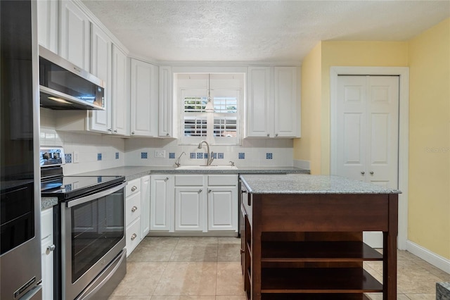 kitchen with a sink, white cabinets, backsplash, and stainless steel appliances