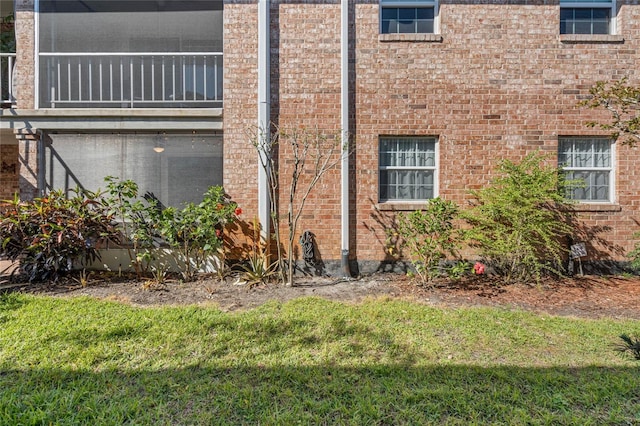 view of property exterior with a yard and brick siding