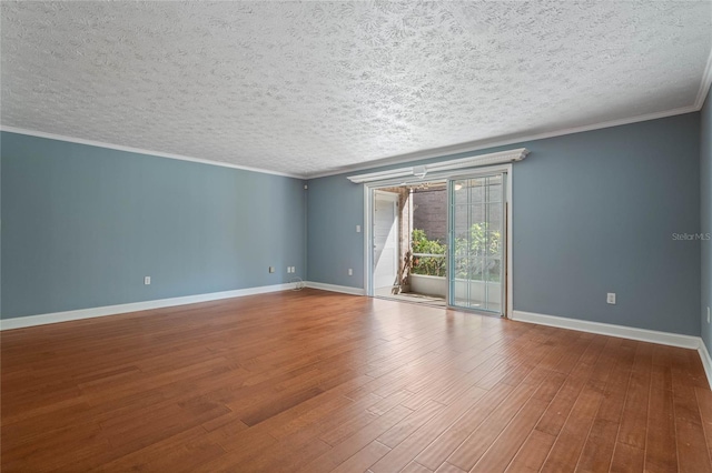 empty room featuring crown molding, wood finished floors, baseboards, and a textured ceiling