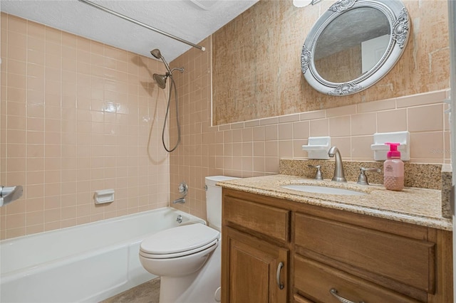 bathroom featuring toilet, a textured ceiling, tile walls,  shower combination, and vanity