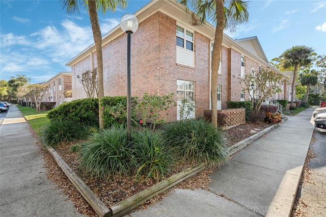 view of side of property featuring brick siding