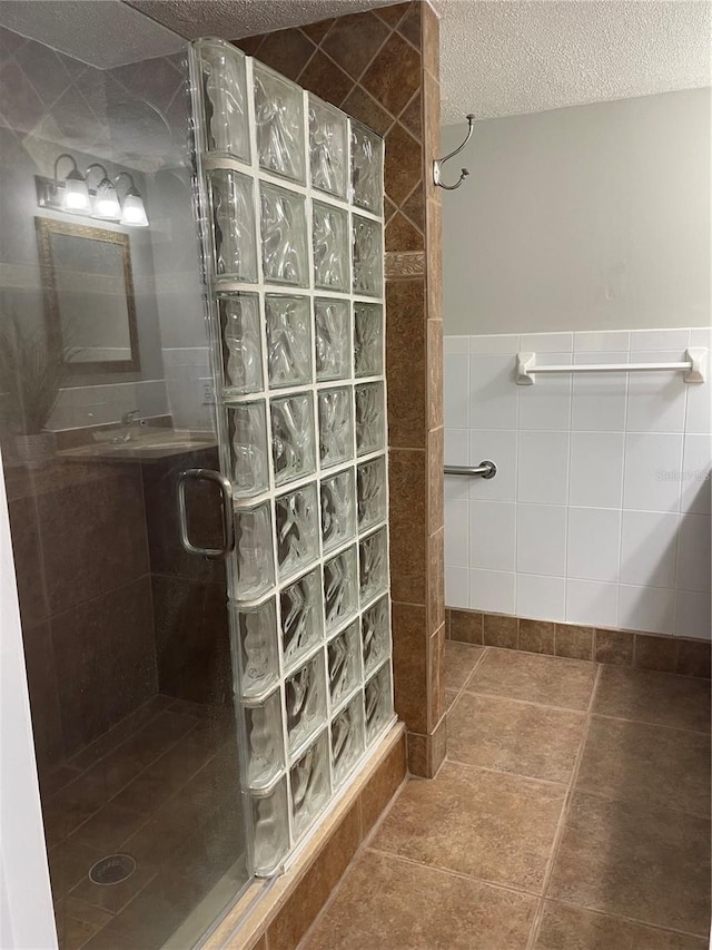 4214 Lake Underhill Rd Unit A, Orlando, FL 32803 - bathroom featuring a stall shower, a textured ceiling, and tile walls