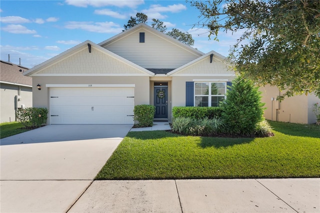 view of front facade with a garage, driveway, a front yard, and stucco siding