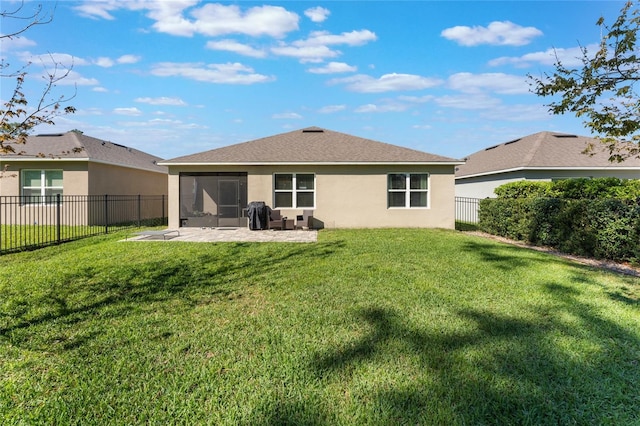 back of house with a fenced backyard, a lawn, and stucco siding