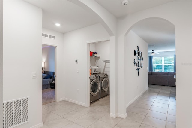 hallway featuring light tile patterned floors, washing machine and clothes dryer, and visible vents