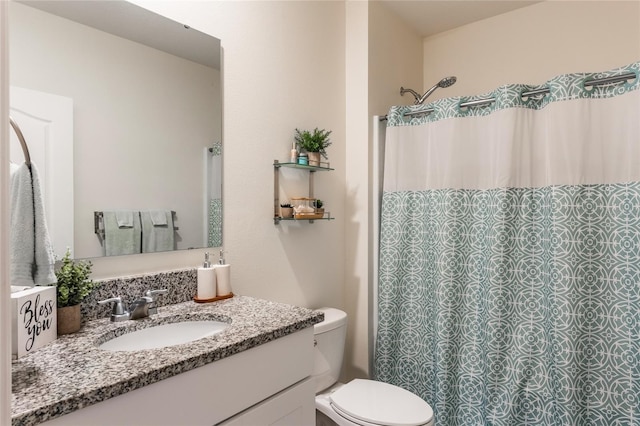 full bath with curtained shower, vanity, and toilet